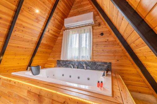 KumlucaKaraöz Sapphire Bungalows的小木屋内的浴缸,设有窗户