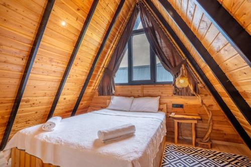 KumlucaKaraöz Sapphire Bungalows的木制客房的一张床位,设有窗户