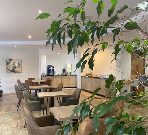 卡尔维卡尔维大酒店的餐厅设有木桌和椅子,种有植物