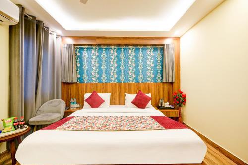 新德里Wood Rose Hotel Near Delhi Airport的一间卧室配有一张带红色枕头的大床