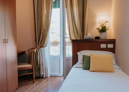 斯特雷萨弗洛拉酒店的一间卧室设有一张床和一个窗口