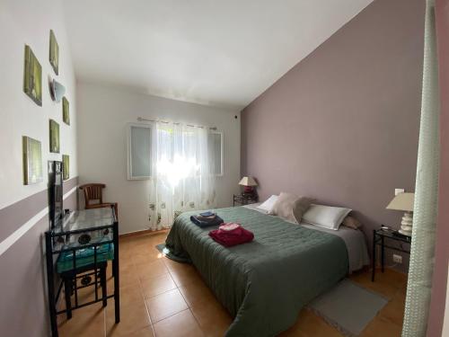 维琪奥港chez Béatrice的一间卧室配有一张床、一张桌子和一个窗户。