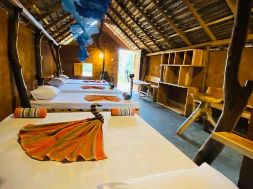 蒂瑟默哈拉默Yala Village Eco Tree House的一间客房内的四张床