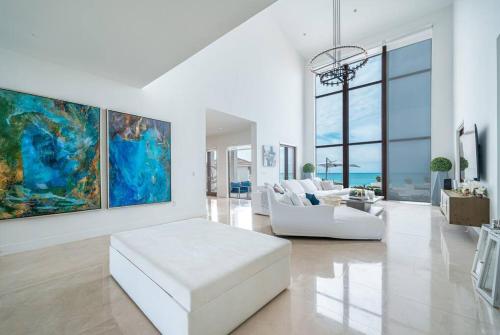 爱丽丝镇The Bahamas Beachfront Dream Villa的客厅配有白色沙发和绘画作品