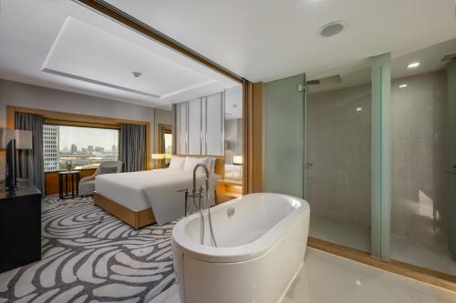 曼谷盛泰澜曼谷拉普崂中央广场酒店的带浴缸和床的酒店客房