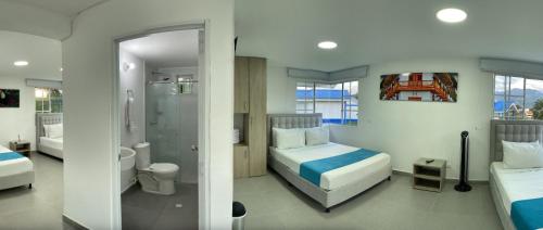 佩雷拉Hotel Villa Mónaco的一间带两张床的卧室和一间浴室