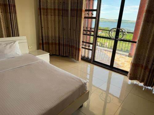 金贾Marina Lake View Apartments,Jinja的一间卧室设有一张床和一个大窗户