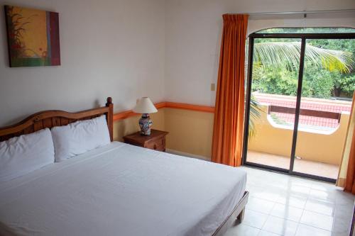 普拉亚卡门Vista Caribe Playa的一间卧室设有一张床和一个大窗户
