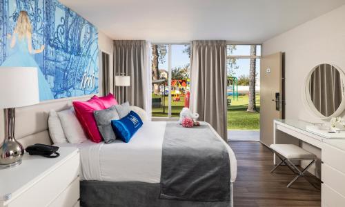 基西米魔法时刻儿童俱乐部酒店的一间卧室配有一张带色彩缤纷枕头的大床