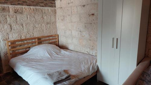 代姆雷Kekova Hassan's Pansiyon的卧室内的一张床位,卧室设有砖墙