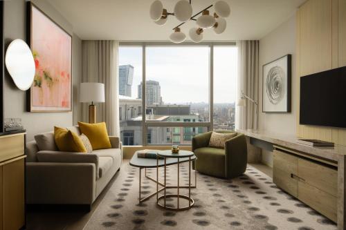 多伦多约克维尔多伦多四季酒店的客厅配有沙发、椅子和电视