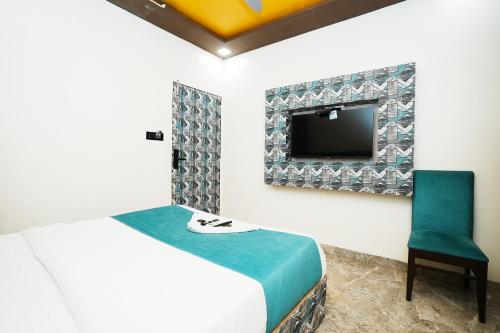 孟买HOTEL VERSOVA INN的配有床、电视和椅子的房间