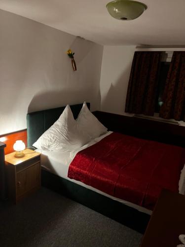 FrickenhausenGasthof Stern Asteri的一间卧室配有一张带红色毯子的床