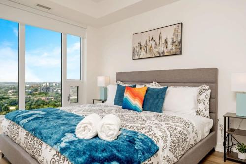 基奇纳Newly Built Condo w Amazing Amenities and Views的一间卧室配有一张大床和两条毛巾