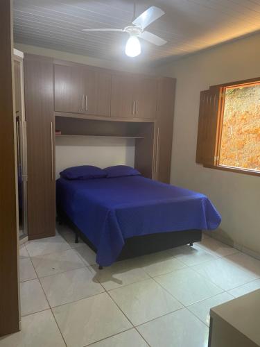 Presidente SoaresCasa de campo的一间卧室配有一张蓝色的床和吊扇