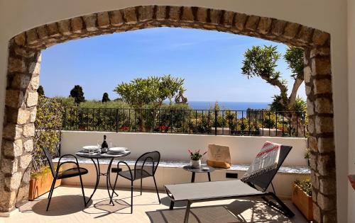 卡普里Le donne di Capri - Charming apartments in Capri的阳台的天井配有桌椅