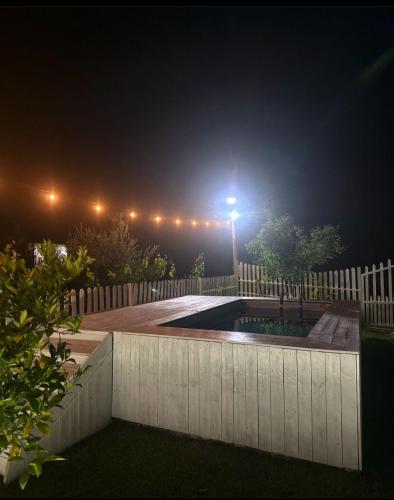PeqinDevis Villa的夜间后院设有围栏和游泳池