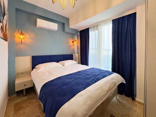 博德鲁姆纳斯住宿加早餐旅馆的一间卧室设有一张带蓝色墙壁和窗户的大床