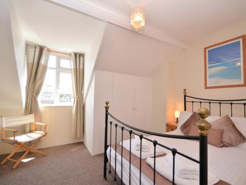 布里克瑟姆3 bed property in Brixham 56862的卧室配有床、椅子和窗户。