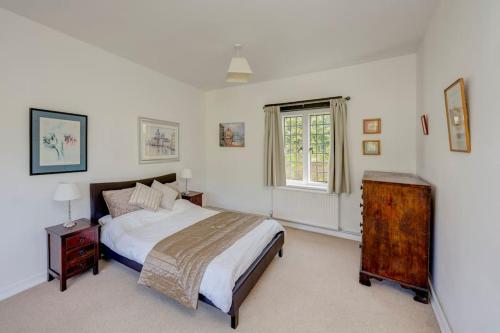 查尔芬特－圣贾尔斯NEW - Beautiful, spacious Beechwood Lodge with lovely gardens的白色的卧室设有床和窗户