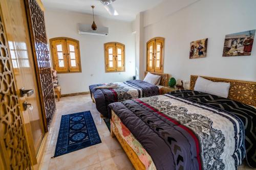卢克索Dar Lina Guesthouse Luxor的一间卧室设有两张床和一扇门