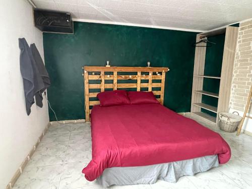 兰斯Le Ranch - proche centre ville的一间卧室设有一张红色的床和绿色的墙壁