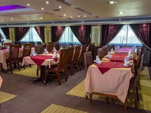 开罗نايل كروز نايل سمارت MS River的用餐室配有桌椅和窗帘
