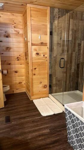 Heber SpringsCabin on the Lake的带淋浴和卫生间的浴室以及木墙。