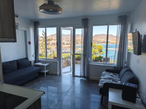 马萨龙港El Faro seacave的带沙发和大窗户的客厅