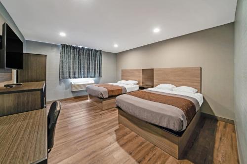 福克斯伯勒福克斯波罗美洲贝斯特唯尤酒店的酒店客房设有两张床和电视。