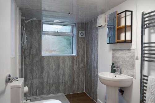 Garden Apartment by Kahuna Stays的一间带水槽和卫生间的浴室以及窗户。