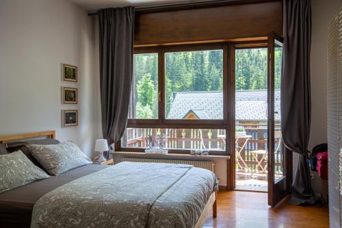 塔尔维西奥La Casa di Carmen的一间卧室设有一张床和一个大窗户