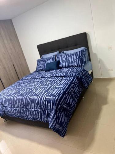 Santa Elenaacogedor apartamento zona este barquisimeto的卧室内的一张带蓝色棉被和枕头的床