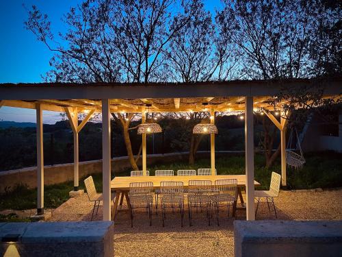 Puyvert#LUXE# Maison de maître provençale的凉亭下的桌椅,配有灯