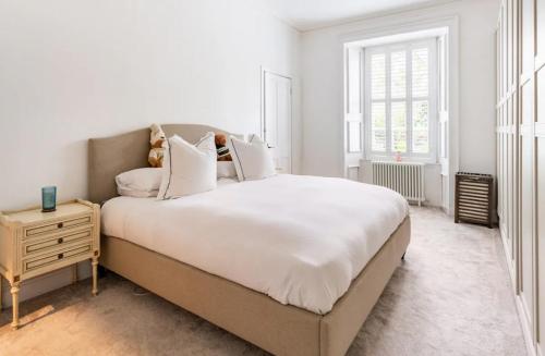 爱丁堡Luxury New Town Apartment的白色卧室设有一张大床和一个床头柜