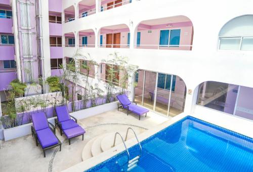 坎昆卡维亚酒店的一个带游泳池和紫色椅子的公寓