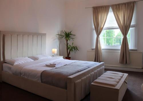 伦敦The Water Works Cottage的卧室设有一张白色大床和一扇窗户。