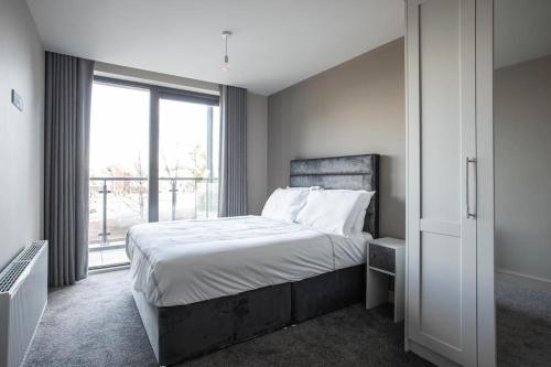 贝尔法斯特Skyline Serenity: Exquisite 3-Bedroom Ultra-Luxury Penthouse的一间卧室设有一张床和一个大窗户