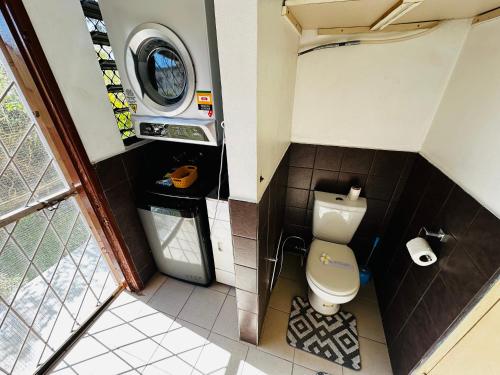 南迪Cozy, Comfortable, Family Home.的一间带卫生间和洗衣机的小浴室