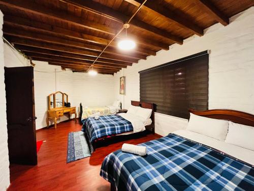 里奥班巴Casa de campo con hermosa vista的一间卧室配有两张床和一张桌子
