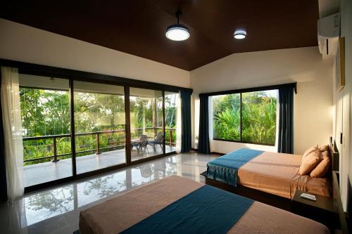 San PedrilloEden Corcovado的一间卧室设有两张床和大窗户