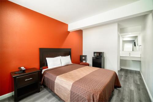 BellBell Manor Motel的一间卧室配有一张橙色墙壁的床