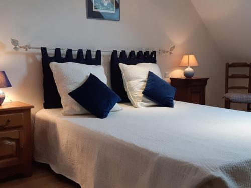 LuzilléGîte Luzillé, 3 pièces, 4 personnes - FR-1-381-303的卧室配有带蓝色枕头的大型白色床