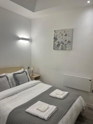 米尔顿凯恩斯Luxurious Short Stay Flat in Milton Keynes的一间卧室配有一张床,上面有两条毛巾