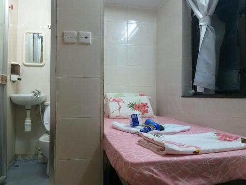 香港NEW WASHINGTON GUEST HOUSE B1,B2 B LOCK 13 FLOOR CHUNG KING MANSHION, 36-44 NATHAN ROAD KOWLOON HONG KONG的浴室设有粉红色的桌子、毛巾和卫生间