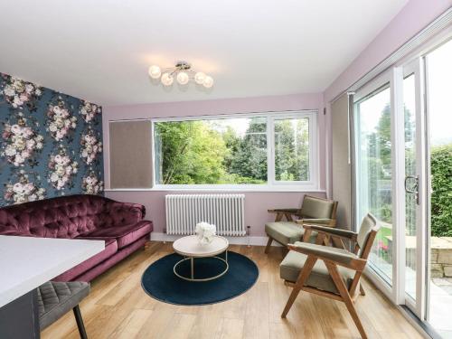 温德米尔Briars Lea的客厅配有紫色沙发和窗户