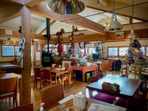 松本乗鞍高原の宿テンガロンハットB&BTengallonhat的餐厅内带桌椅的用餐室