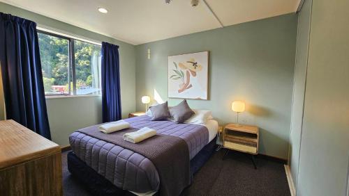 弗朗兹约瑟夫Franz Josef Montrose Lodge的一间卧室配有一张床,上面有两条毛巾