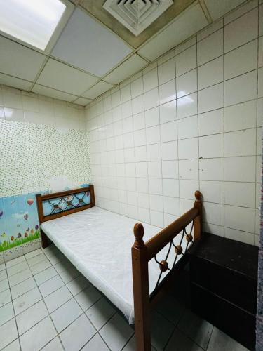 阿布扎比small room PM new location的小房间设有床铺和瓷砖墙