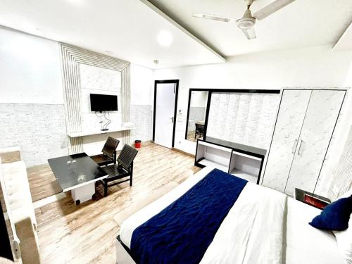 新德里The Tomar Hospitality的一间卧室配有一张床、一张书桌和一台电视